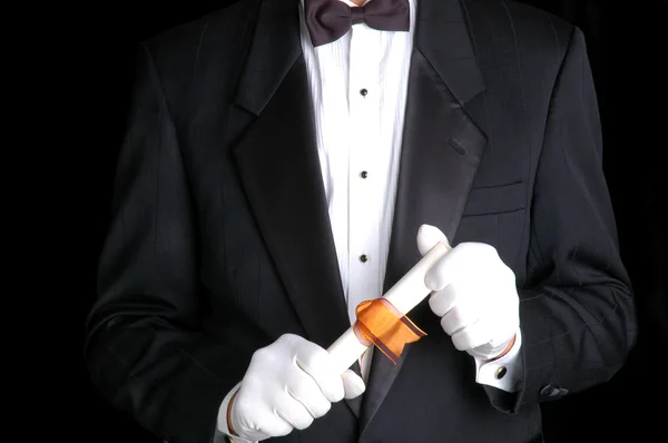 Mann im Smoking hält Schriftrolle mit Schleife — Stockfoto