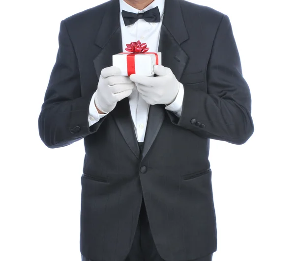 Mand i Tux holder en lille gave - Stock-foto