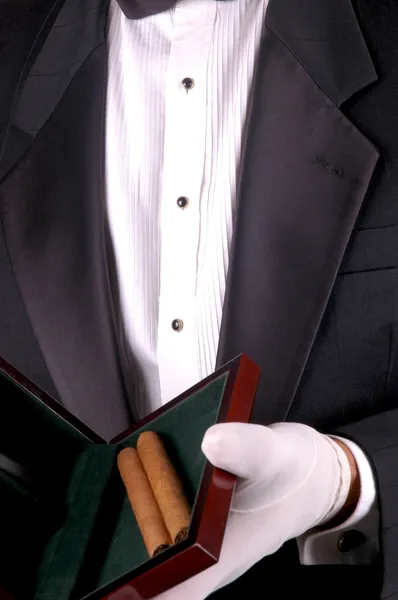 Человек в смокинге с сигарами — стоковое фото