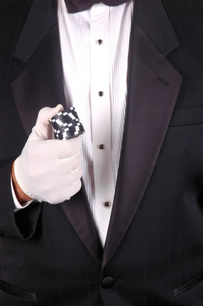 Человек в смокинге с фишками для покера — стоковое фото