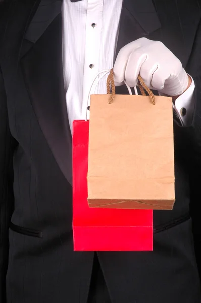 Человек в смокинге с двумя сумками — стоковое фото