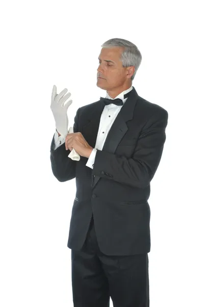 Man in tux zetten witte handschoenen — Stockfoto