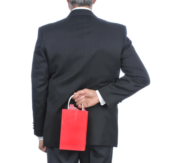Homem com saco de presente atrás das costas — Fotografia de Stock