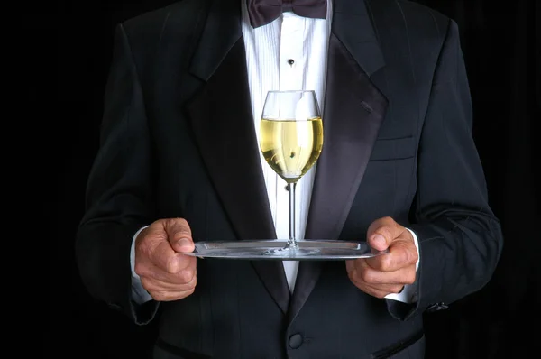 Homem segurando um copo de vinho em uma bandeja — Fotografia de Stock