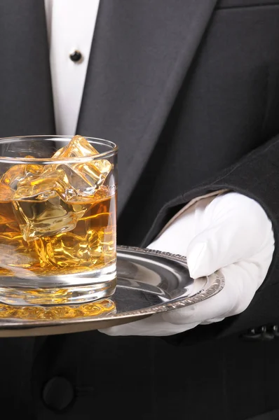 Butler sosteniendo vaso de whisky en la bandeja —  Fotos de Stock