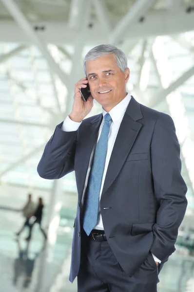 Улыбающийся бизнесмен разговаривает по мобильному телефону — стоковое фото