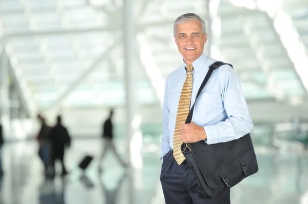Hombre de negocios sonriente con bolsa de viaje — Foto de Stock