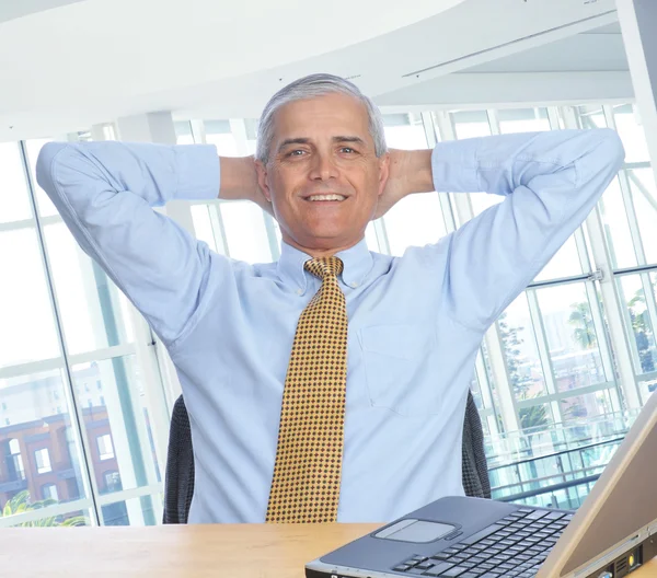 Mann am Schreibtisch Hände hinter dem Kopf — Stockfoto