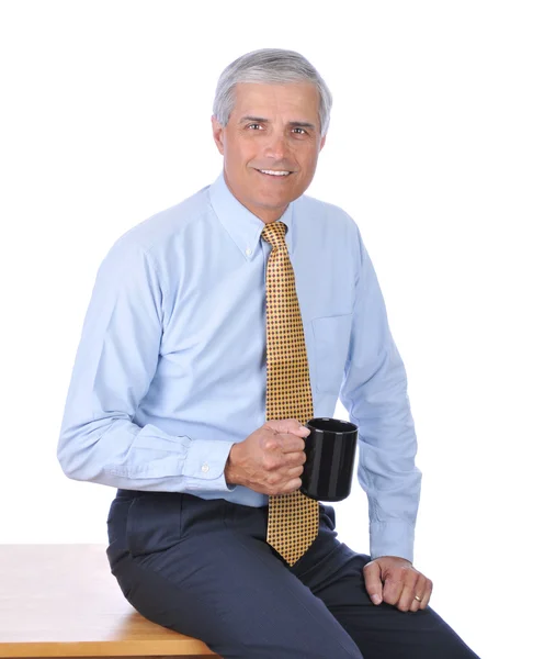 Businessman Sitting on Desk With Coffee — Stockfoto