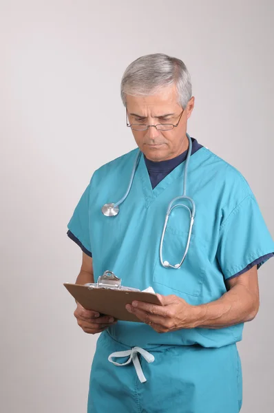 Medico in Scrubs con appunti — Foto Stock