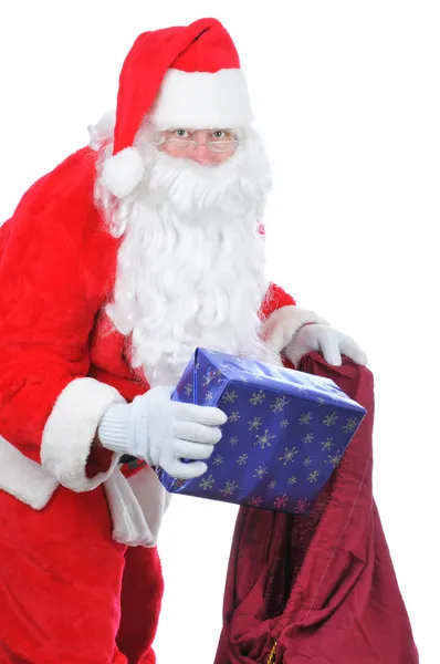 Weihnachtsmann legt Geschenk in Tüte — Stockfoto