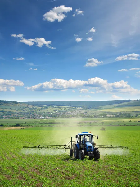 Farming tractor plowing and spraying — Stock Photo, Image