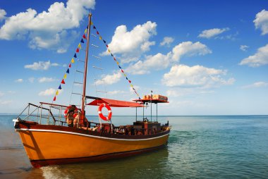 Orange, lonely Boat in Caribbean clipart