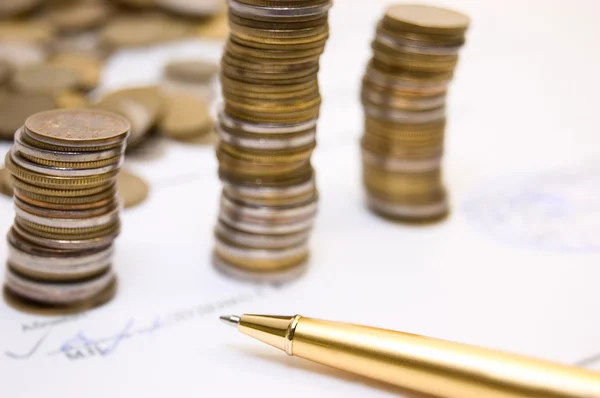 Coins on written contract with pen — Stock Photo, Image