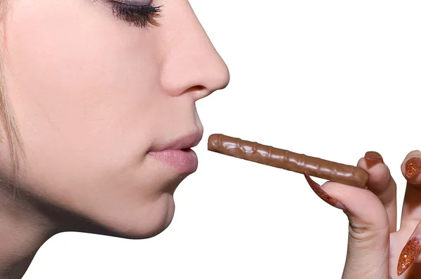 Female hand hold chocolate at lips — Stock Photo, Image