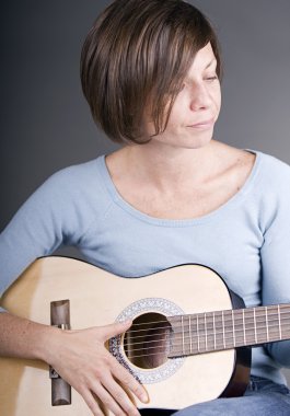 Kadın gitar çalıyor.