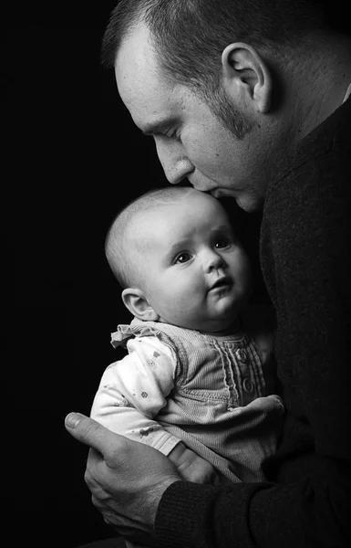 Beundrande far pussar sin baby dotters huvud Royaltyfria Stockbilder