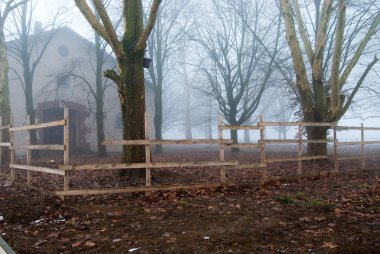 Foggy house behind the wooden fence clipart