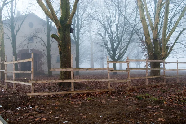 Ομίχλη σπίτι πίσω από το ξύλινο φράχτη — Φωτογραφία Αρχείου
