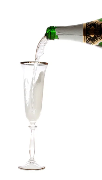 Champagner fließt aus der Flasche im Glas. — Stockfoto