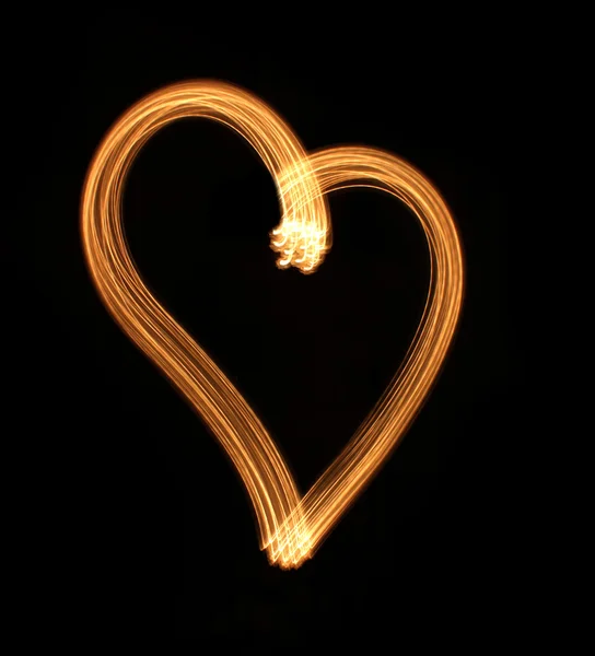 Hjärtat från ljus på en svart bakgrund. — Stockfoto