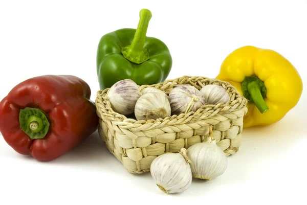 Bell peppers and basket with garlics — Stock Photo, Image