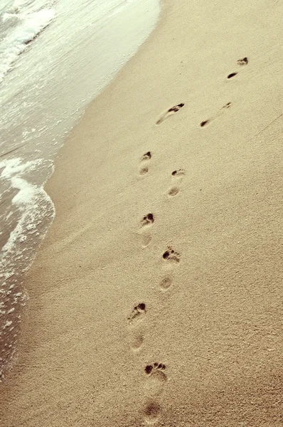 Po stopách potiskem vedle sebe v písku — Stock fotografie