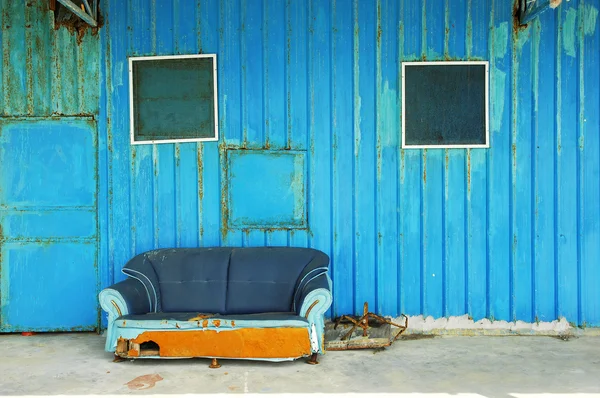 Vieja casa abandonada frente con sofá azul —  Fotos de Stock
