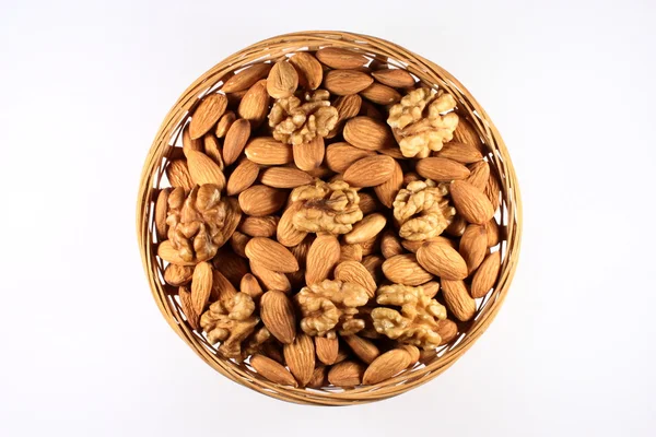 Миндаль и грецкие орехи в круглой корзине — стоковое фото