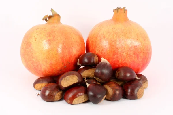 Two pomegranates and chestnuts — Stock Photo, Image