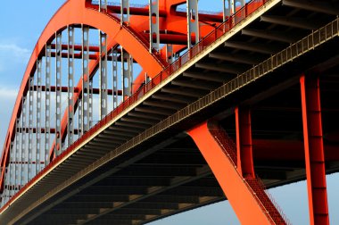 turuncu renkli çelik kablo köprü mavi gökyüzünde yüksek kaldı.