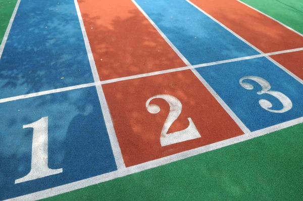 stock image The colorful courses with white numbers on the playground.