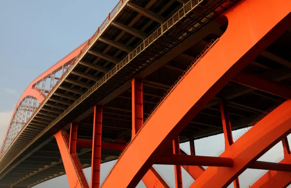 A narancssárga színű acél kábel maradt a kék ég magas híd. — Stock Fotó