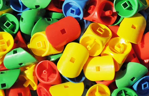 Των πλαστικών παιχνιδιών για παιδιά με αντίθεση χρωμάτων κίτρινο, κόκκινο, μπλε και πράσινο. — Φωτογραφία Αρχείου