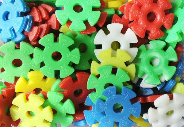 The plastic gear wheels of different contrast colors background.