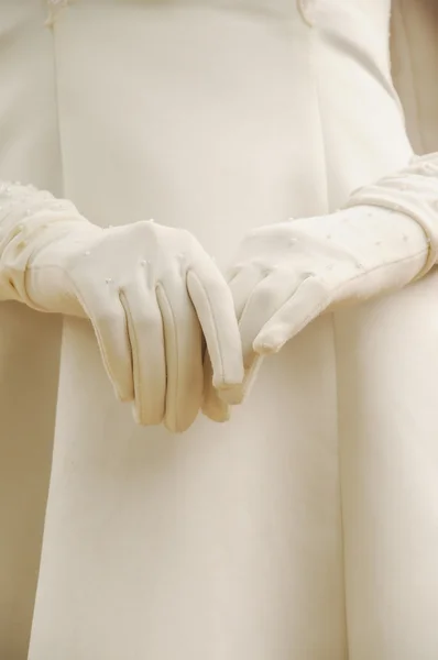 Die Hände der jungen Frau in weißen Handschuhen im weißen Gewand bei der Trauung. — Stockfoto