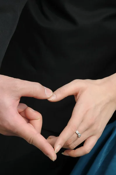 Jeune couple main dans la main formant une forme de coeur dans la cérémonie de mariage . — Photo