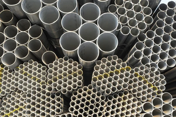 The round steel tubes of various size and caliber pile background. — Stock Photo, Image