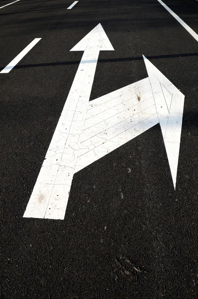 The white direction arrows on road