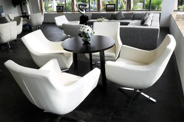 A sala de salão da empresa com cadeiras de couro giratórias brancas e mesa de chá redonda . — Fotografia de Stock