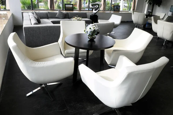 La salle de salon de l'entreprise avec chaises pivotantes en cuir blanc et table à thé ronde . — Photo