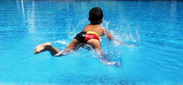 Menino brincando na piscina — Fotografia de Stock