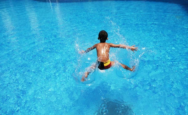 Boy playing in swiming pool — Stock Photo, Image