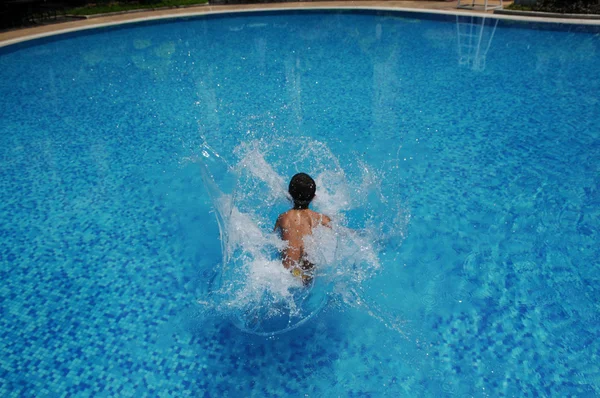 Boy playing in swiming pool — Stock Photo, Image