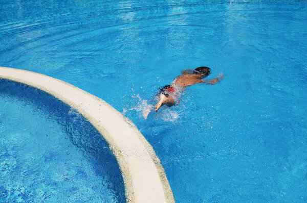 Мальчик играет в бассейне
