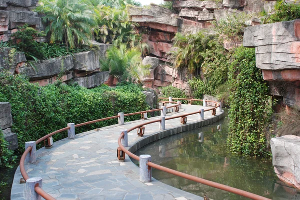 A ponte de tábua de madeira em um jardim de lagoa de água em um resort tropical China . — Fotografia de Stock