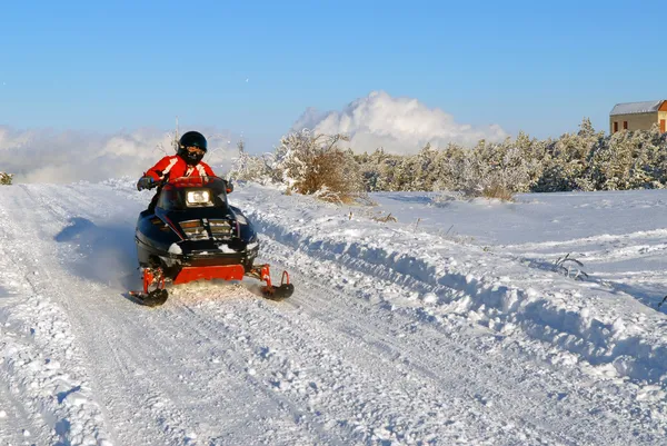 Der Mann fährt mit dem Schneemobil — Stockfoto