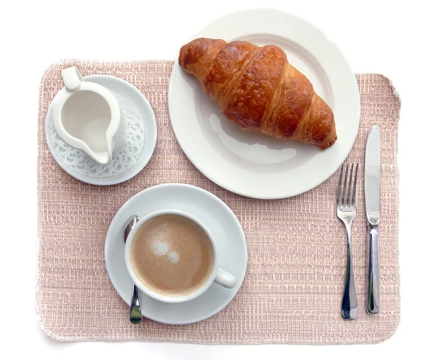 Xícara de café com croissant em uma mesa — Fotografia de Stock