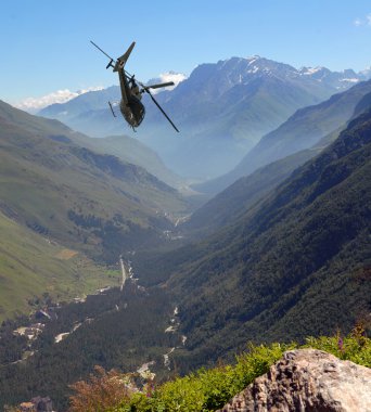 The helicopter flies in mountains clipart