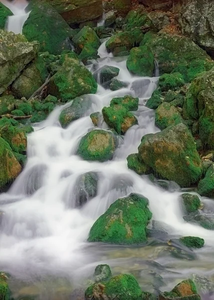 Водопады среди зеленых камней — стоковое фото